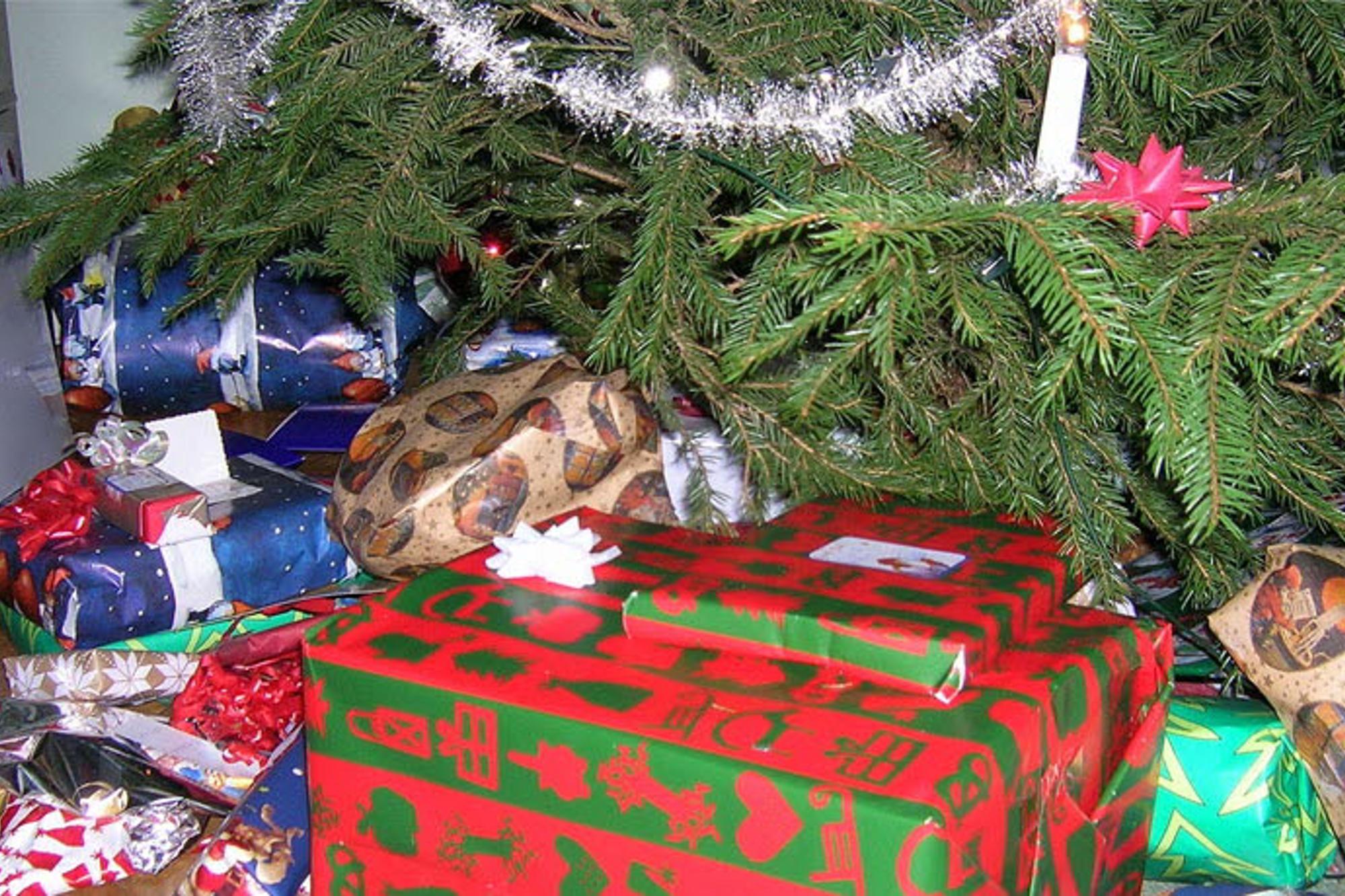 En hög av inslagna julklappar som ligger under en julgran.